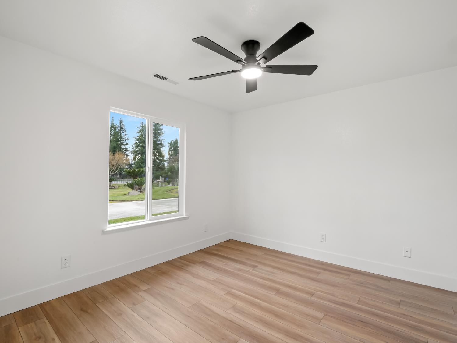 7284 West Rialto Avenue Fresno, CA 93723 - Photo 29 of 60 an empty room with wooden floor fan and windows