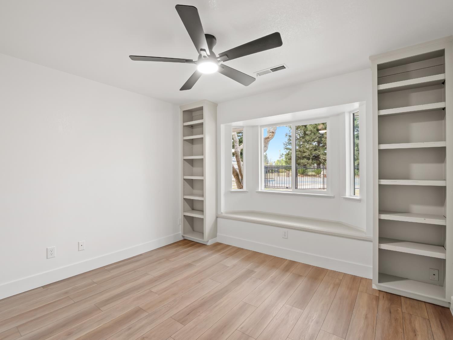 7284 West Rialto Avenue Fresno, CA 93723 - Photo 30 of 60 a view of an empty room with a window and wooden floor