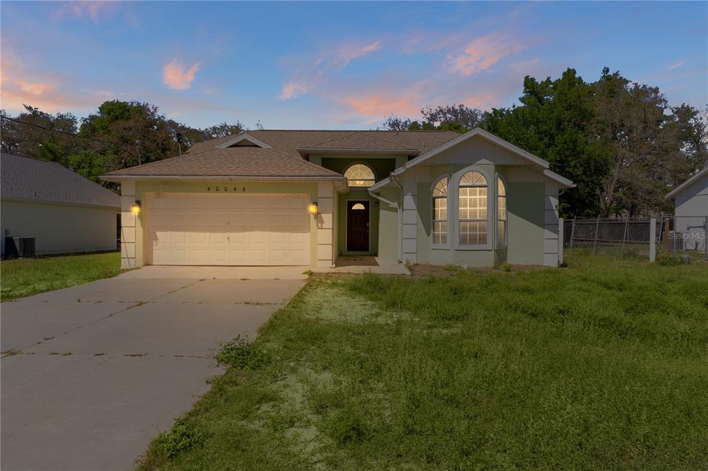 40045 Palm Street Lady Lake, FL 32159 - Photo 2 of 50 a front view of a house with a yard and garage