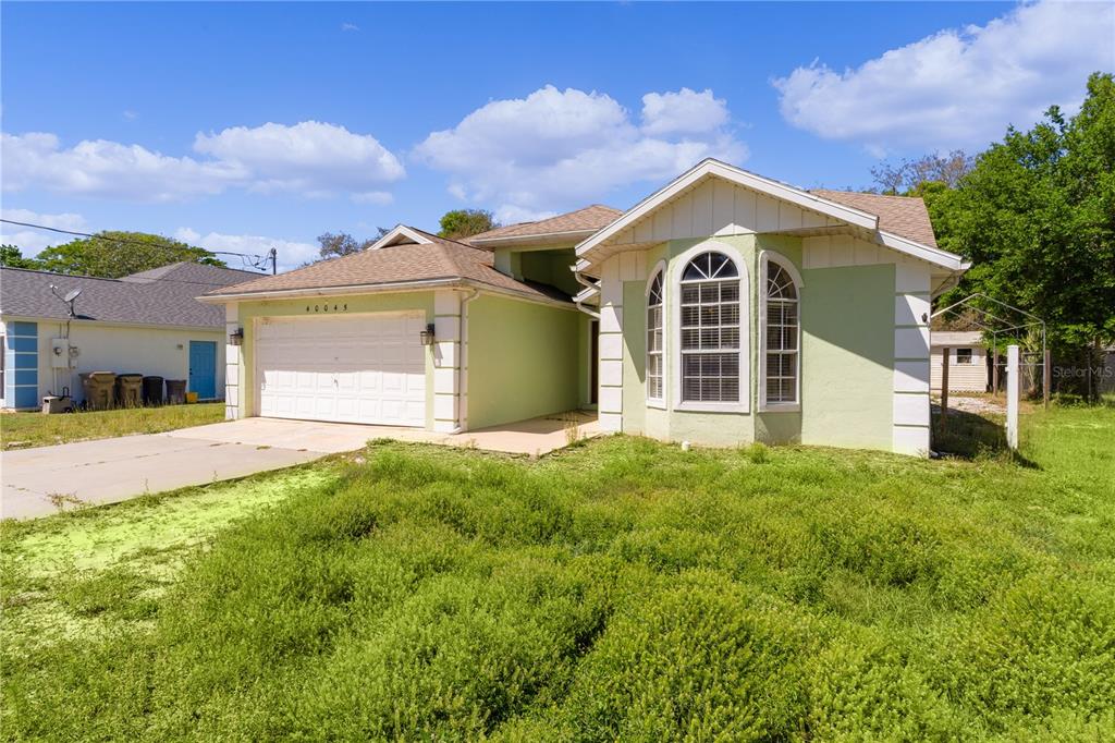 40045 Palm Street Lady Lake, FL 32159 - Photo 21 of 50 a front view of a house with a yard and garage