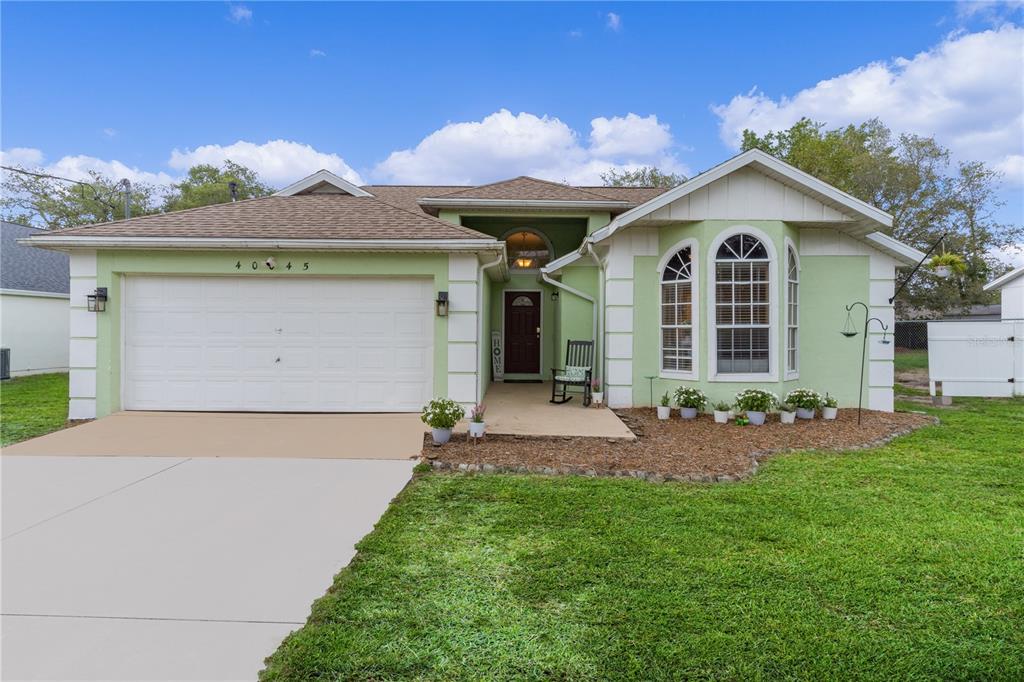 40045 Palm Street Lady Lake, FL 32159 - Photo 3 of 50 a front view of a house with a yard and garage