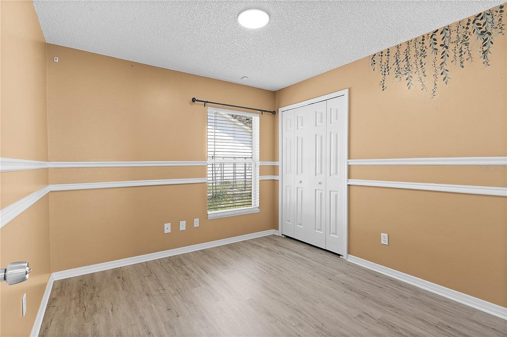 40045 Palm Street Lady Lake, FL 32159 - Photo 32 of 50 an empty room with wooden floor and windows with curtains