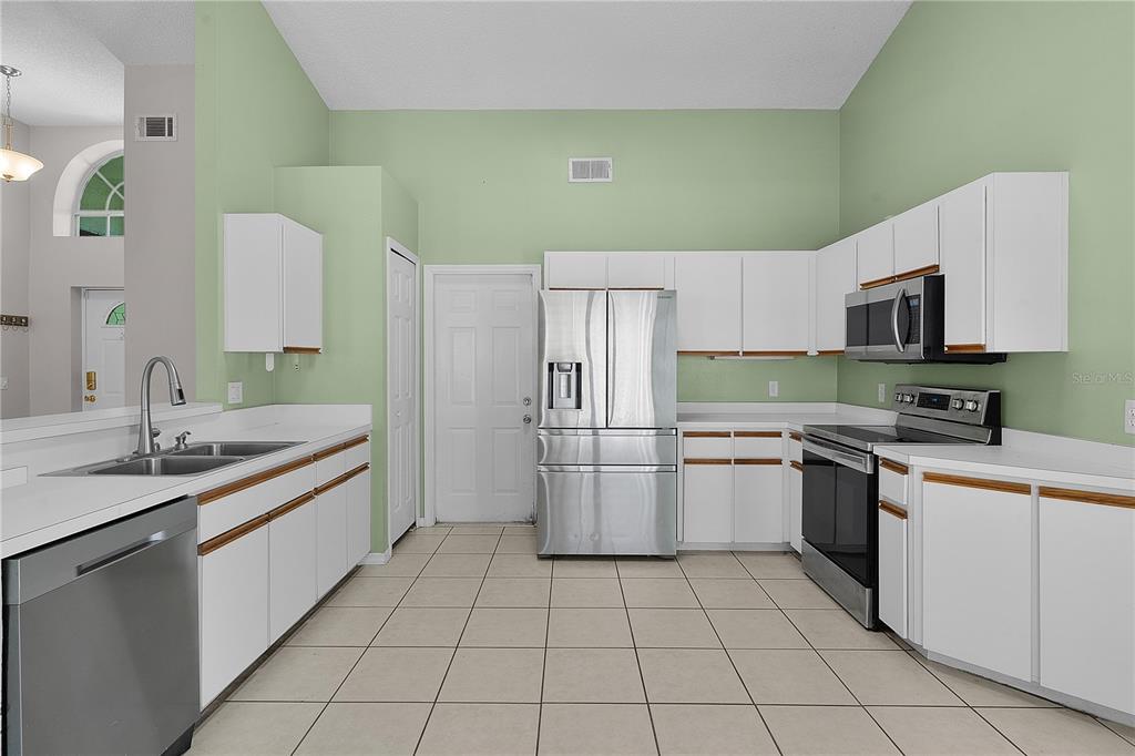 40045 Palm Street Lady Lake, FL 32159 - Photo 36 of 50 a kitchen with a sink a stove top oven and cabinets