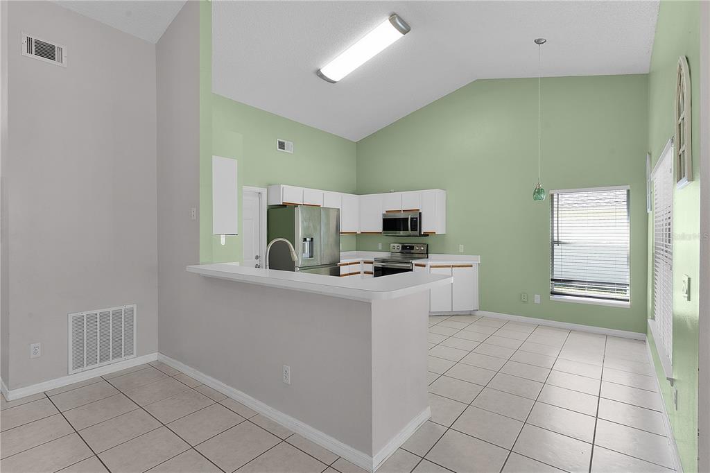 40045 Palm Street Lady Lake, FL 32159 - Photo 40 of 50 a kitchen with stainless steel appliances a refrigerator sink and microwave