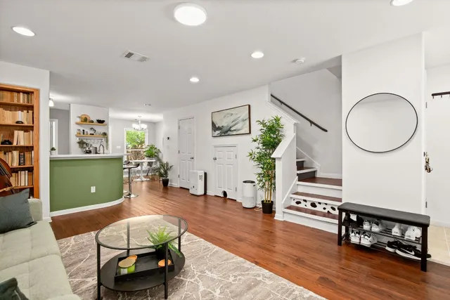 a living room with furniture a dining table and paintings on the wall