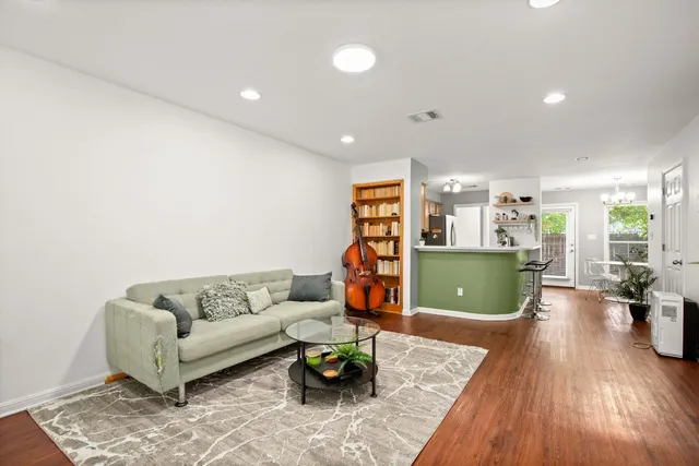 a living room with furniture and a wooden floor