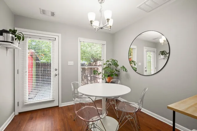 a view of a dining room with furniture a potted plant and wooden floor