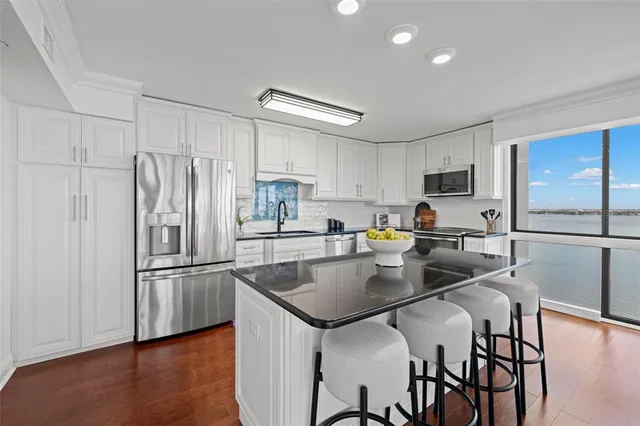 a kitchen with kitchen island a refrigerator stove microwave and cabinets
