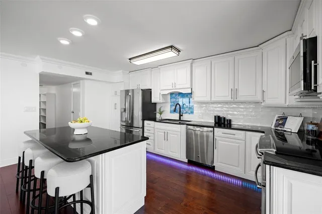 a kitchen with refrigerator cabinets and wooden floor