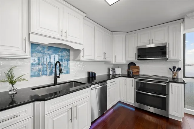 a kitchen with appliances a sink and cabinets