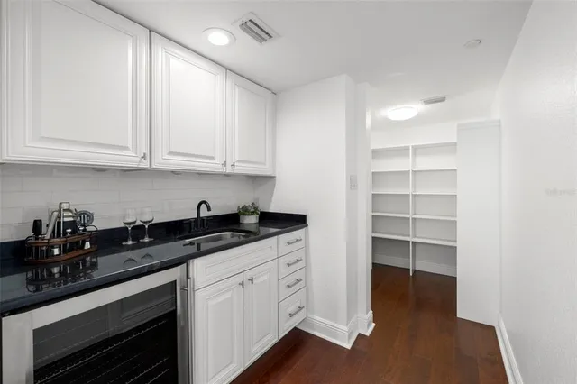 a kitchen with granite countertop white cabinets and black appliances