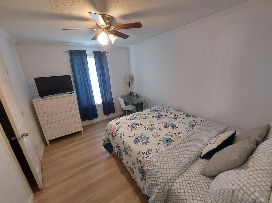 1401 West 9th Street Riviera Beach, FL 33404 - Photo 10 of 17 a bedroom with a bed and a flat tv screen on a dresser