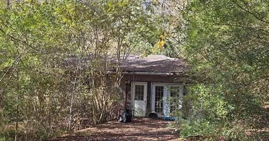 a front view of a house with a tree