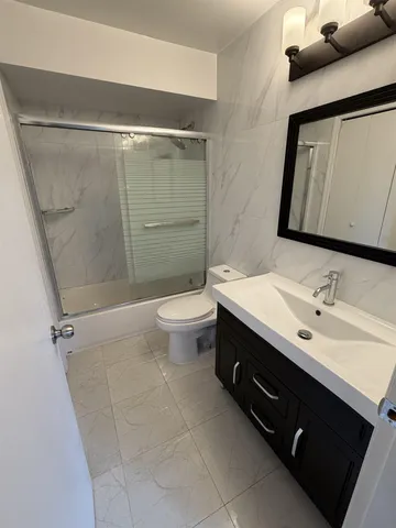 a bathroom with a double vanity sink mirror and toilet