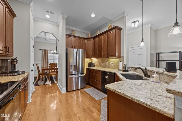 a dining room with furniture a chandelier and wooden floor