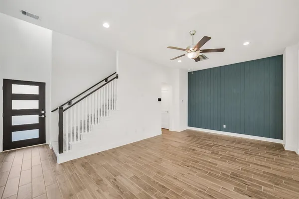 a view of an empty room with window and wooden floor