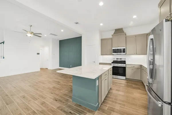 a kitchen with granite countertop a sink stainless steel appliances and cabinets