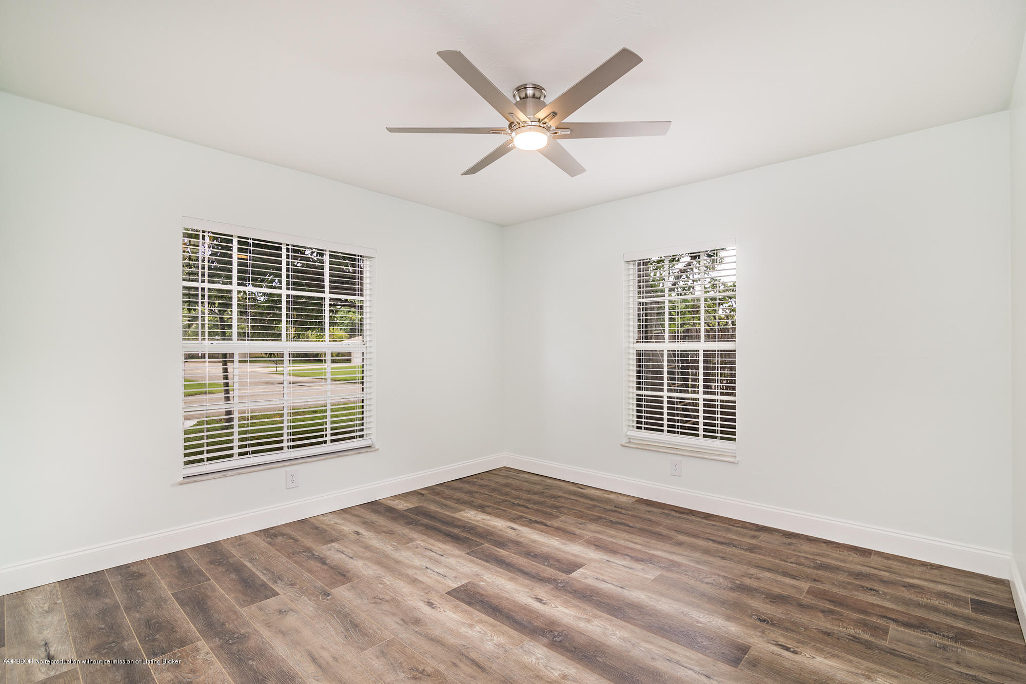 1870 Travis Road West Palm Beach, FL 33406 - Photo 21 of 35 an empty room with wooden floor windows and ceiling fan