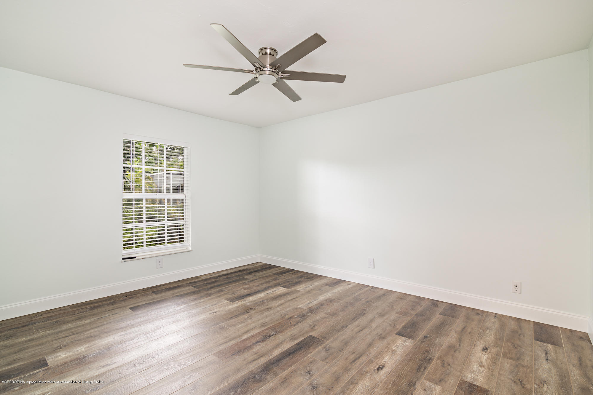 1870 Travis Road West Palm Beach, FL 33406 - Photo 23 of 35 an empty room with wooden floor fan and windows