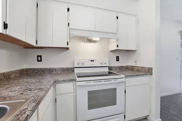 a kitchen with appliances a sink and a window