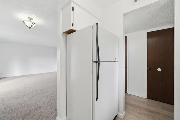 an empty room with kitchen and white walls