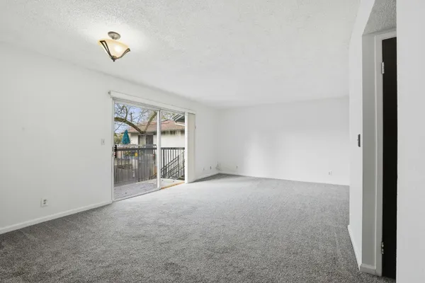 a view of an empty room with closet and a window
