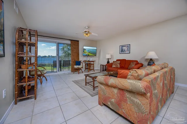 a living room with furniture a bookshelf and a window