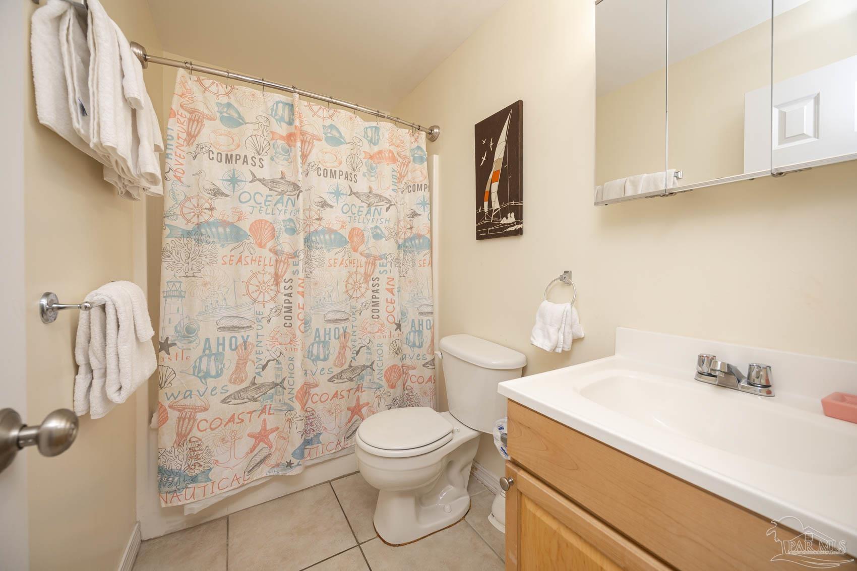 16470 Perdido Key Drive, Unit B13 Perdido Key, FL 32507 - Photo 17 of 30 a bathroom with a sink a toilet and shower curtain