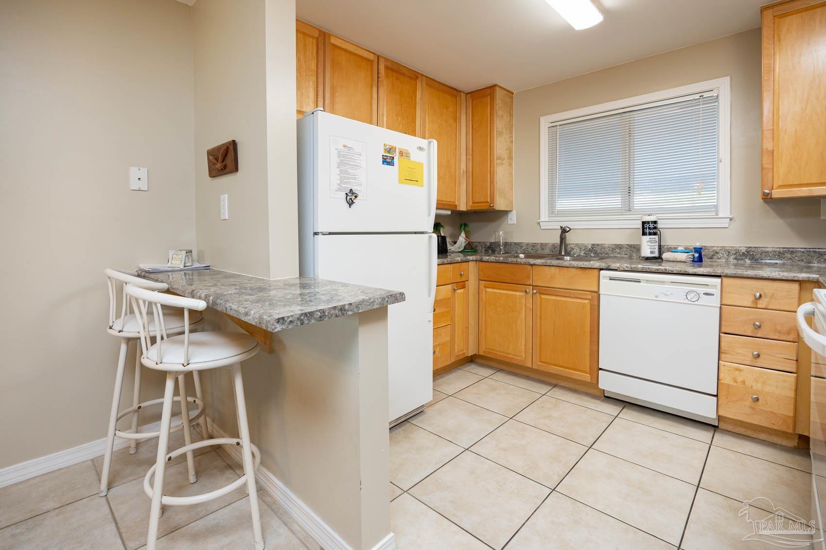 16470 Perdido Key Drive, Unit B13 Perdido Key, FL 32507 - Photo 8 of 30 a kitchen with cabinets and chairs