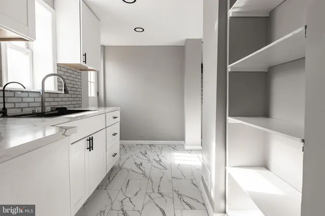 a kitchen with granite countertop white cabinets and white appliances