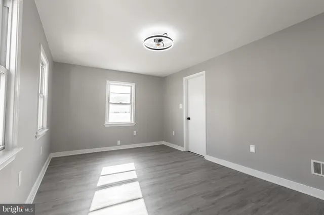 a view of an empty room with wooden floor