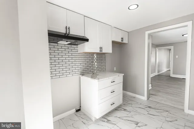 a kitchen with cabinets and a wooden floor