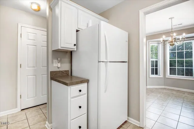 a kitchen with white cabinets and white appliances