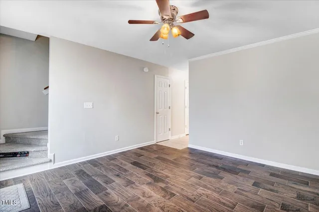 an empty room with wooden floor and window