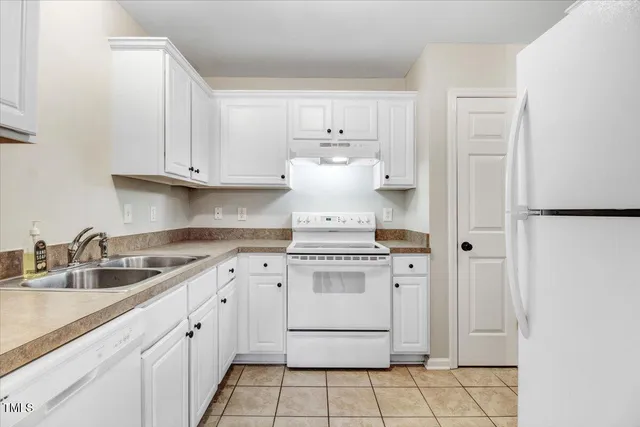 a kitchen with white cabinets and white appliances