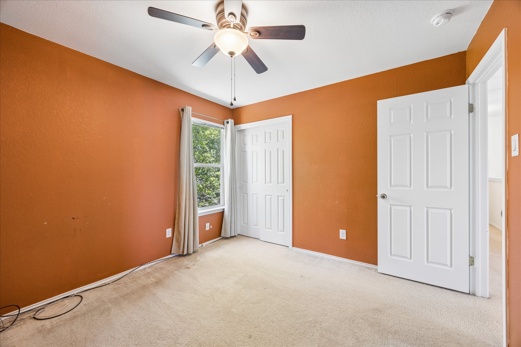 338 Spring Branch Loop Kyle, TX 78640 - Photo 22 of 36 An inviting room features a functional ceiling fan, carpeted flooring, and a large window providing verdant outdoor views.