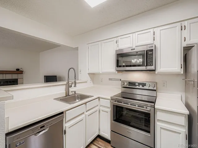 a kitchen with a sink cabinets and wooden floor