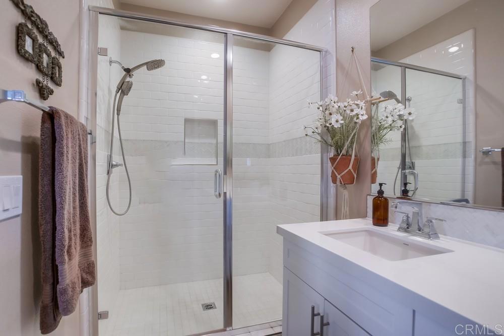 4326 Star Path Way, Unit 1 Oceanside, CA 92056 - Photo 46 of 72 a bathroom with a granite countertop shower sink and mirror