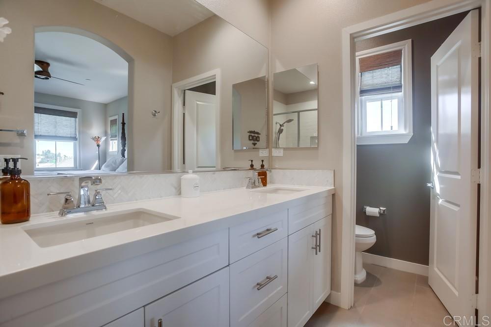4326 Star Path Way, Unit 1 Oceanside, CA 92056 - Photo 47 of 72 a bathroom with double vanity sink a toilet and a mirror