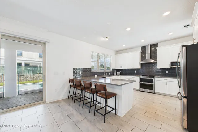 a kitchen with a sink and chairs