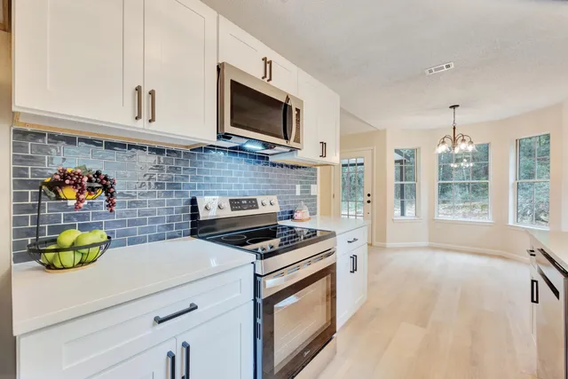 a kitchen with stainless steel appliances a stove microwave and sink
