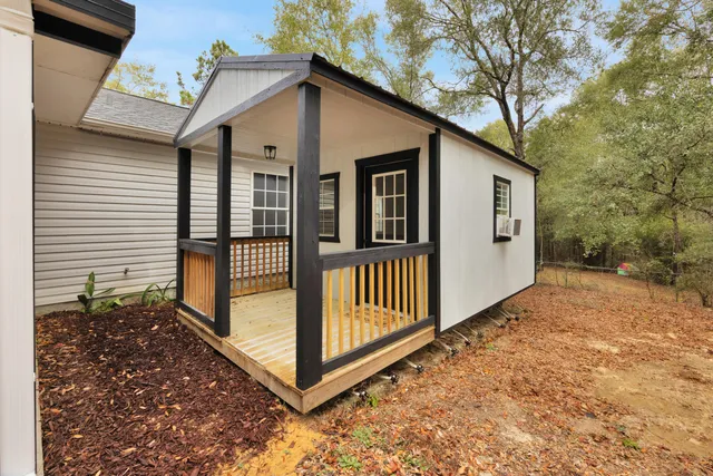 a view of a house with backyard and wooden fence