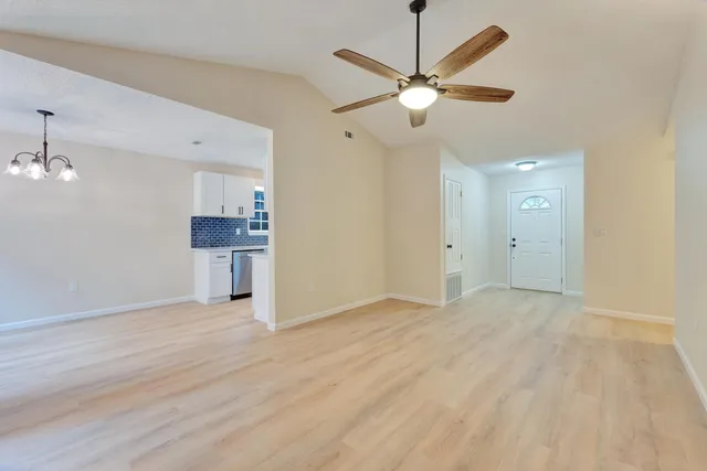 an empty room with a ceiling fan and a window