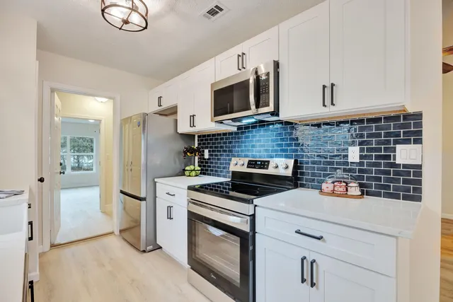 a kitchen with stainless steel appliances a stove microwave and refrigerator