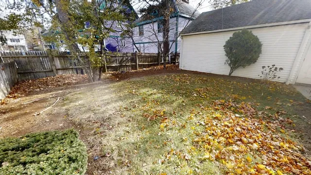 a backyard of a house with table and chairs