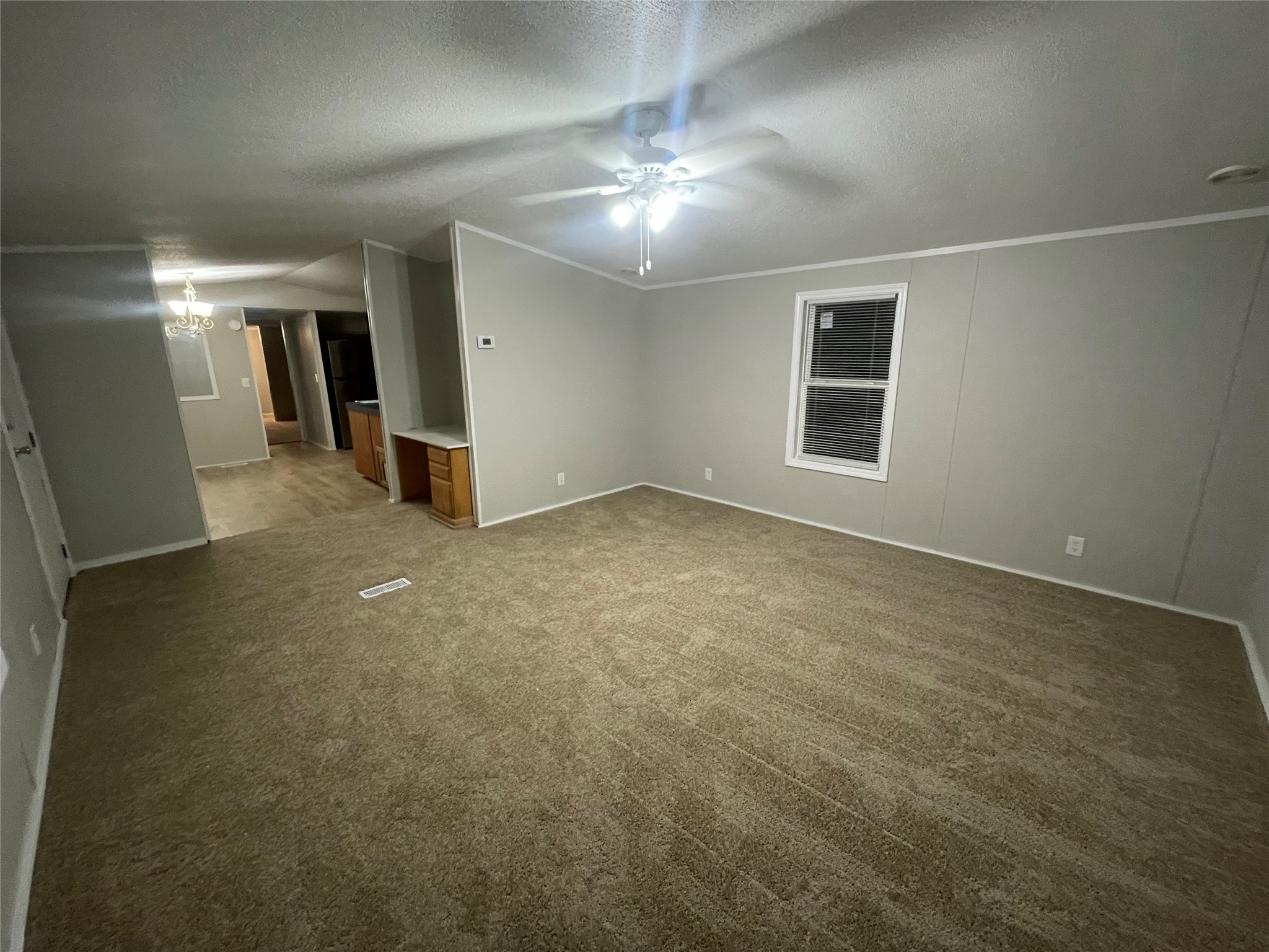 215 Greenfield Road Kyle, TX 78640 - Photo 6 of 8 A well-lit interior space features plush carpeting and a modern ceiling fan.