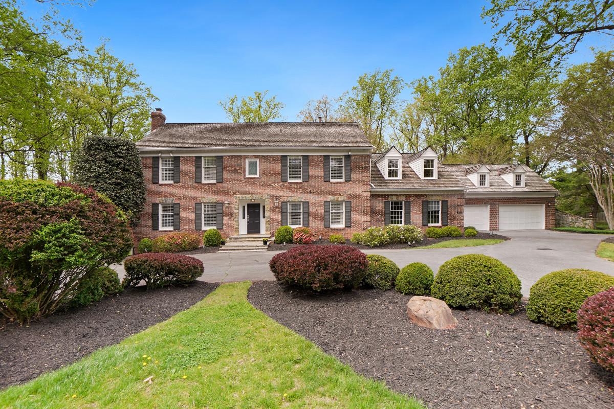 Classic brick colonial home with lush landscaping.