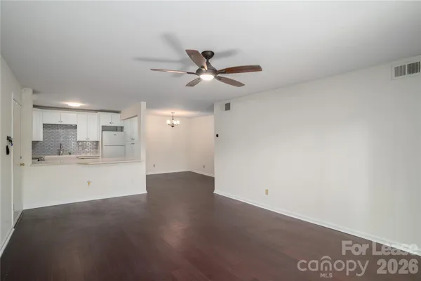 a view of a kitchen with wooden floor and a ceiling fan