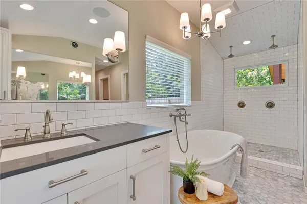 a bathroom with a granite countertop sink a large mirror and shower