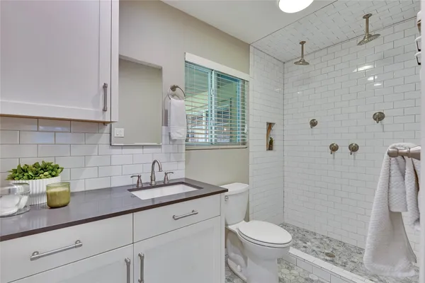 a bathroom with a sink a toilet and shower